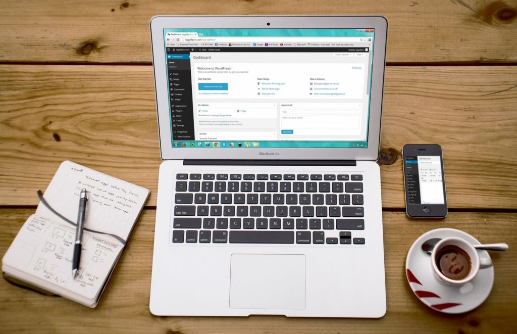 How to Add a Free AI Chatbot WordPress Plugin with AI Marketing Expert – Turn Visitors into Leads 2 A cozy home office scene with a laptop, notebook, smartphone, and coffee, perfect for productivity.