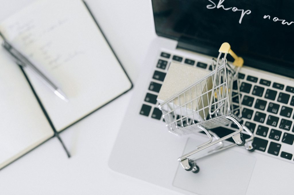 How to Recover Lost Sales: A Guide to Automated WooCommerce Abandoned Cart Recovery with AI 1 Creative depiction of online shopping with a miniature cart on a laptop keyboard.