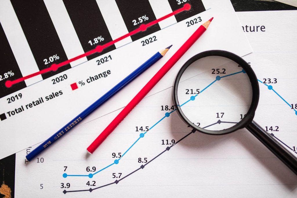 Mapping Your Topical Authority: A Comprehensive Guide to SEO Dominance 1 Magnifying glass and colored pencils on financial trend graphs highlighting sales growth.