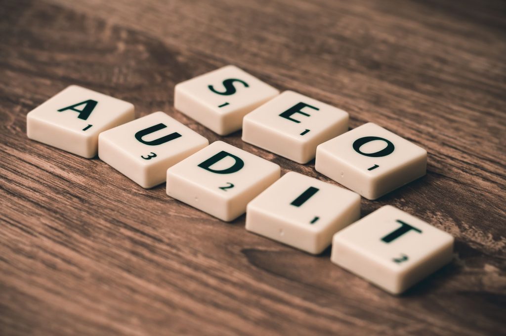 Complete WordPress SEO Audit Framework: How an AI Tool Diagnoses Every Issue in Minutes 1 Scrabble tiles spelling SEO Audit on wooden surface, symbolizing digital marketing strategies.